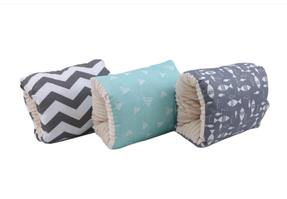 Three rolled fabric baby blankets with different patterns are displayed side-by-side on a plain white background. The left blanket features a black and white chevron pattern, the middle blanket is light blue with small white triangle prints, and the right blanket is slate blue with white fish prints.